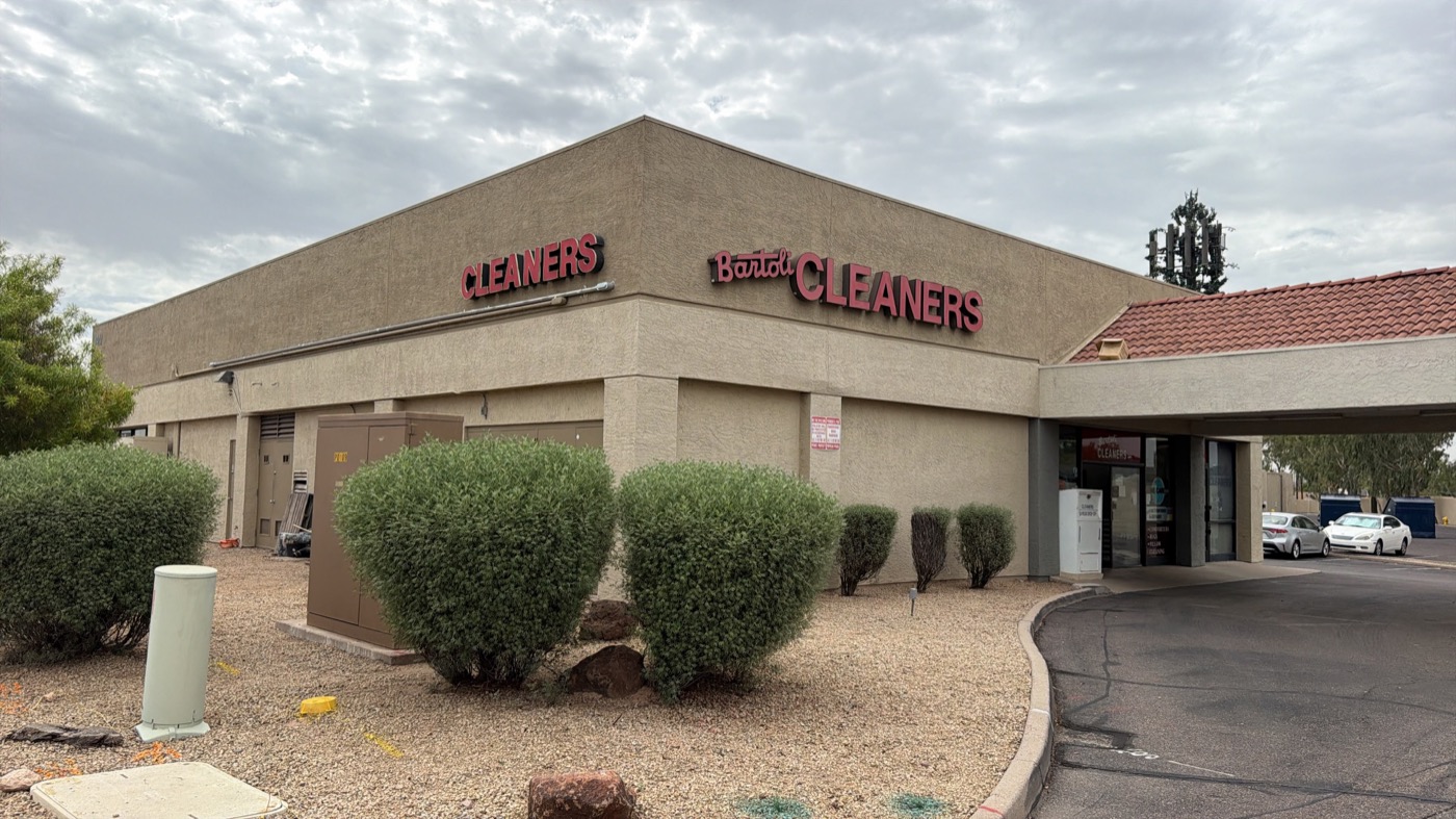 Bartoli Cleaners entrance in Mesa showing comforter, rug and pillow cleaning and expert alterations and repairs
